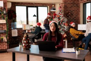 Woman working in a Santa hat- Seasonal Employment blog featured image