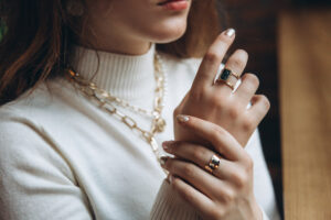 Woman wearing rings and necklaces- Jewelry Insurance blog featured image