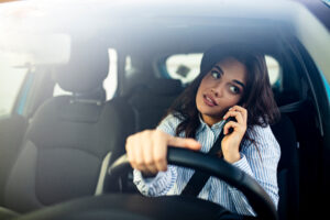 Woman on the phone while driving- Distracted Driving blog featured image