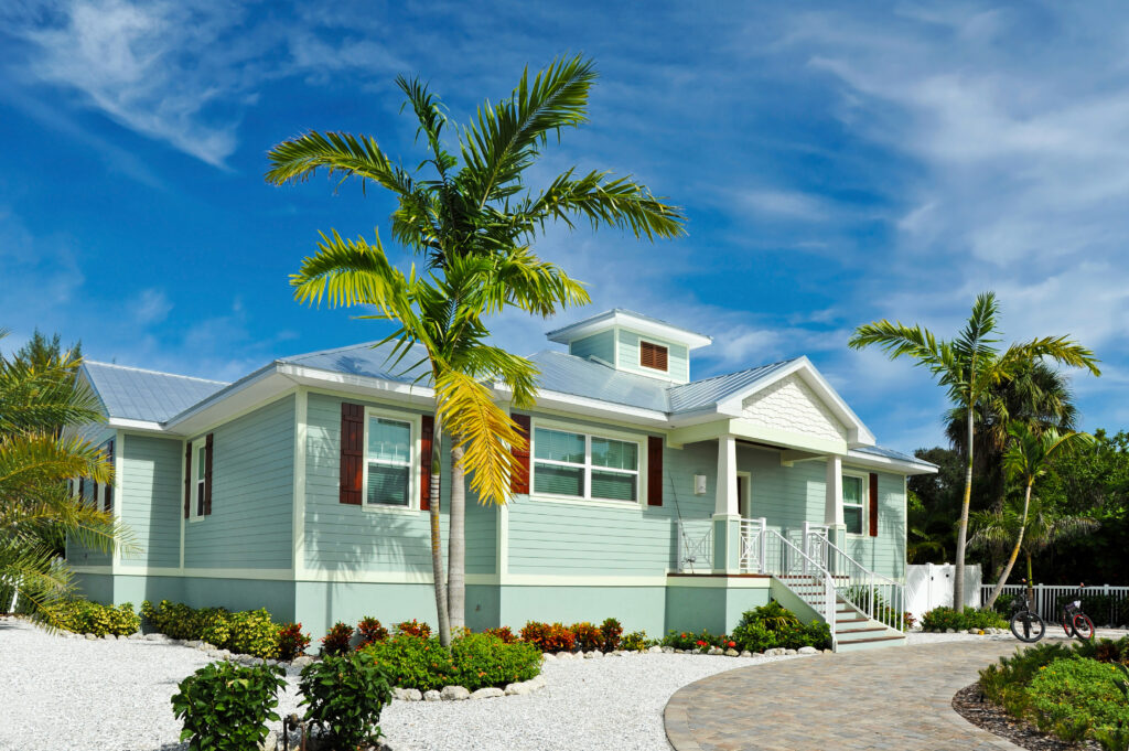 Image of a teal beach house- Beach House Maintenance blog featured image