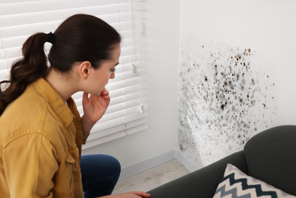 Image of a woman finding mold in her home- Mold Prevention blog featured image