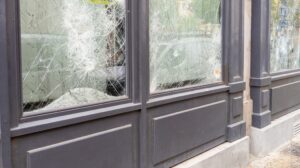 Image of 3 store windows shattered- Requirements for Direct Damage in Commercial Property Insurance blog featured image