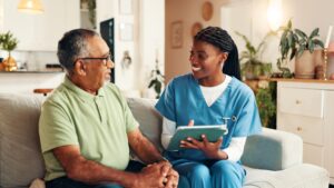 Image of a female doctor talking to an older man- Medicare enrollment blog featured image