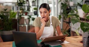 Image of a woman in an apron looking at her tablet and iPad- Commercial Umbrella Insurance blog featured image